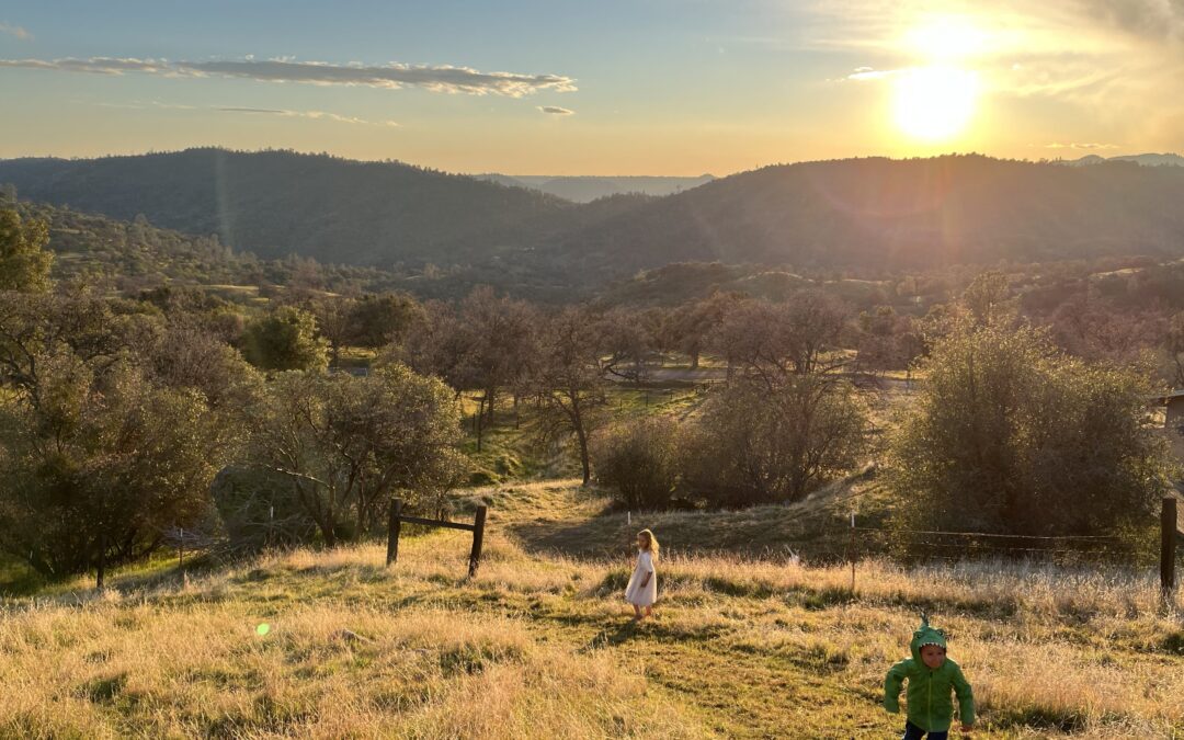 Two children running along hills of North Fork, CA