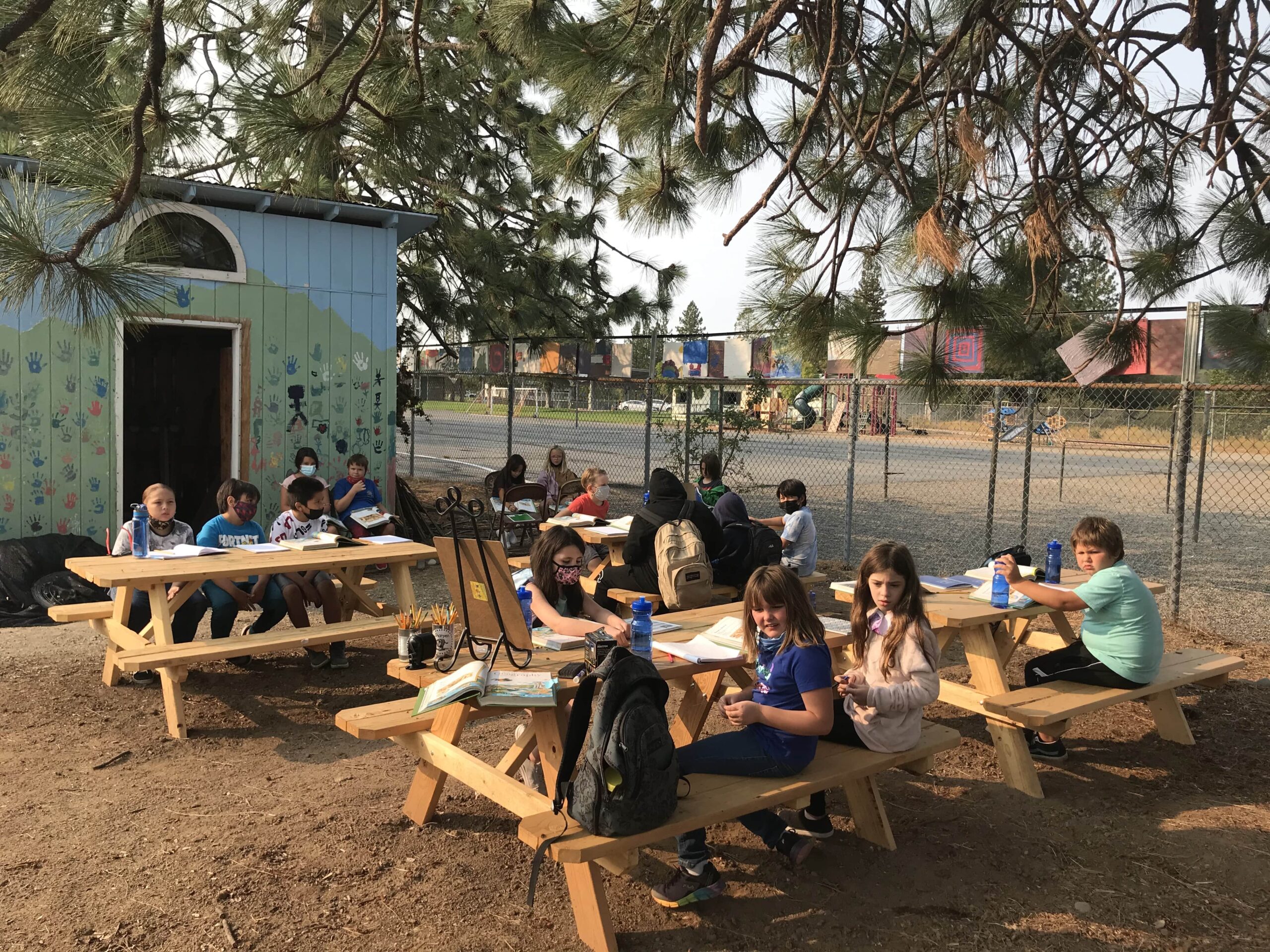 North Fork Elementary students sitting at picnic tables in their outdoor classroom